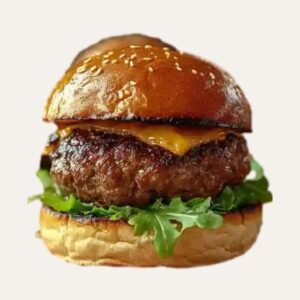 Gros plan sur "Le P'tit Frenchy" : un mini burger boeuf juteux avec son bun artisanal, cheddar fondu, roquette et oignon rouge, grillé à la perfection.