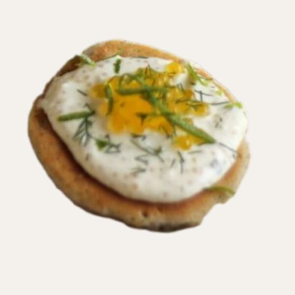 Bouchée apéritive asiatique "Racines d'Asie" à Nantes, servie sur un blini et garnie d'une crème d'edamame et d'une tranche de radis noir