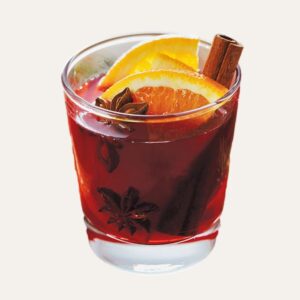 Verre de vin chaud sans alcool artisanal fumant, avec orange et cannelle, servi par votre traiteur à Nantes et Vitré.