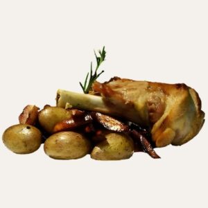 Souris d'agneau confite servie sur un lit de pommes de terre grenailles rôties.