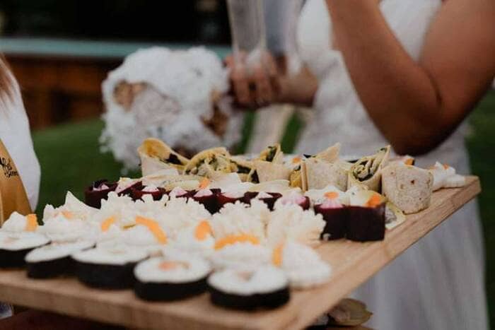 Traiteur pour Particulier Nantes 44 Vitré 35 - Traiteur Événementiel Nantes & Vitré | Restonomade Service traiteur pour particulier lors d'une grande réception ensoleillée en plein air avec de nombreux invités.