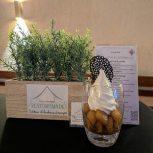 Le charbon tatin - Traiteur Événementiel Nantes & Vitré | Restonomade Le Charbon de Tatin de Restonomade, traiteur nantais à Sainte-Luce-sur-Loire, présente une verrine de pommes confites surmontée d'une glace italienne et d'une dentelle noire artisanale.